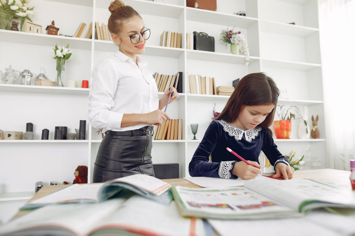 Un professeur particulier aide un élève à son bureau pendant un cours à domicile
